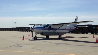 Image of C208 aircraft SKV with a row of UPS trucks